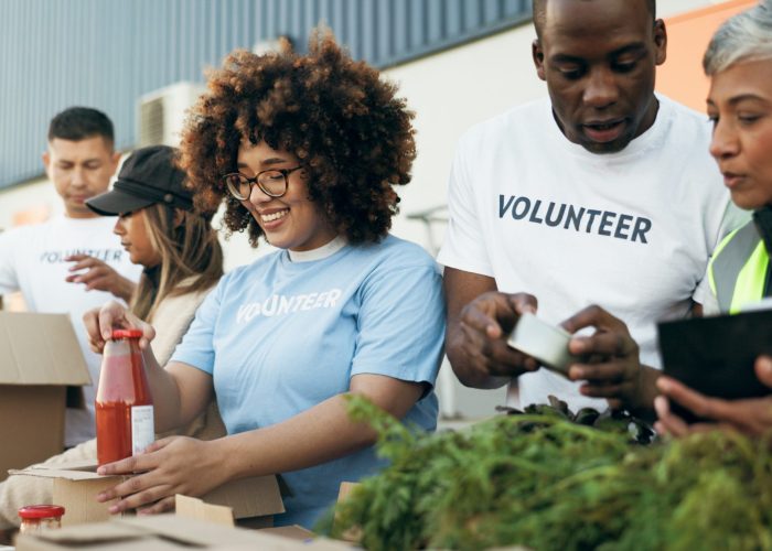Group of people, volunteer and checking food boxes on table for charity with care, kindness and hel.